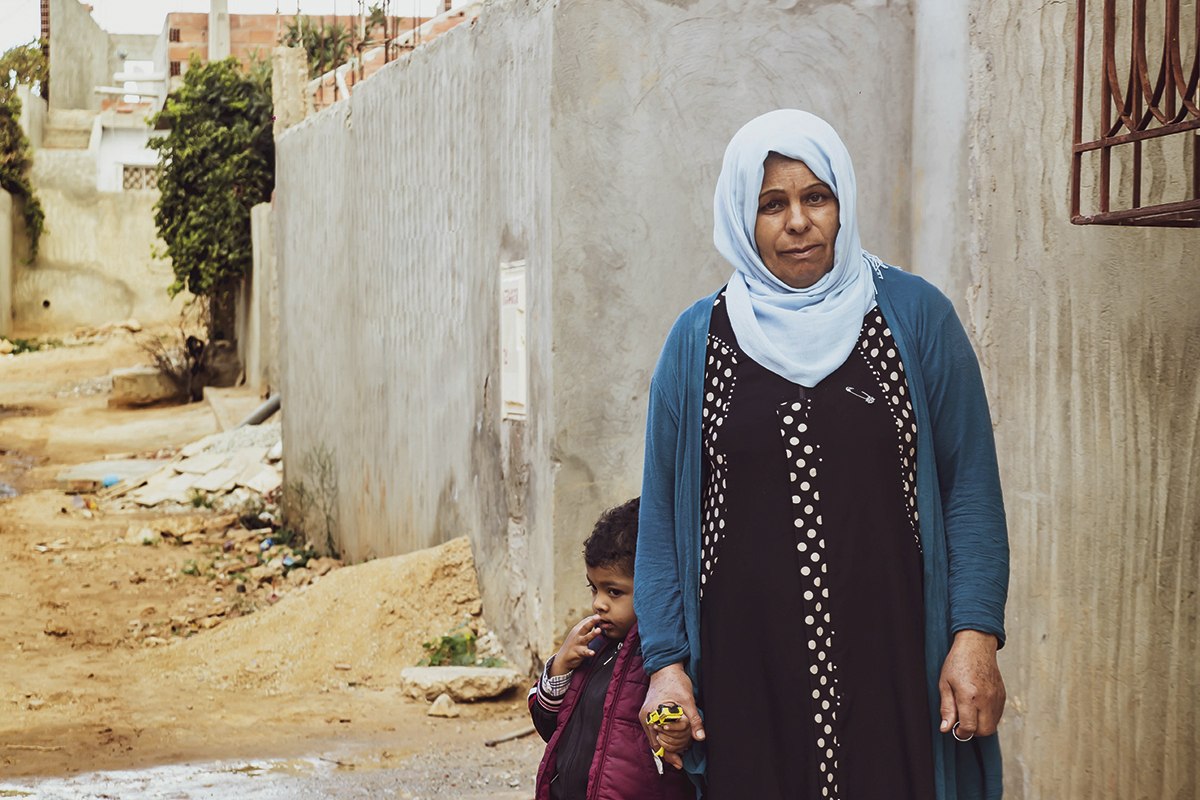 Une mère près de Tunis, démunie d’eau potable courante mais disposant d’un point d’eau commun