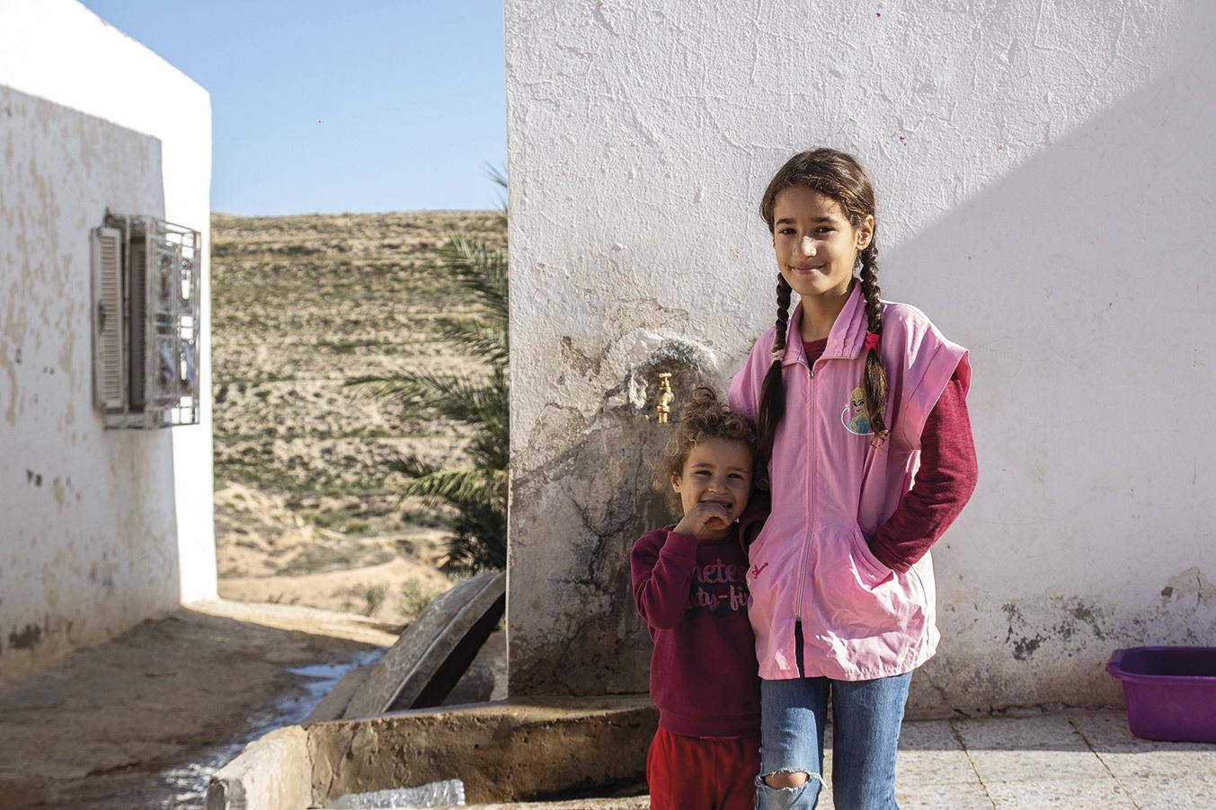 A young schoolgirl in Tunis, lacks clean running water but has a common water point