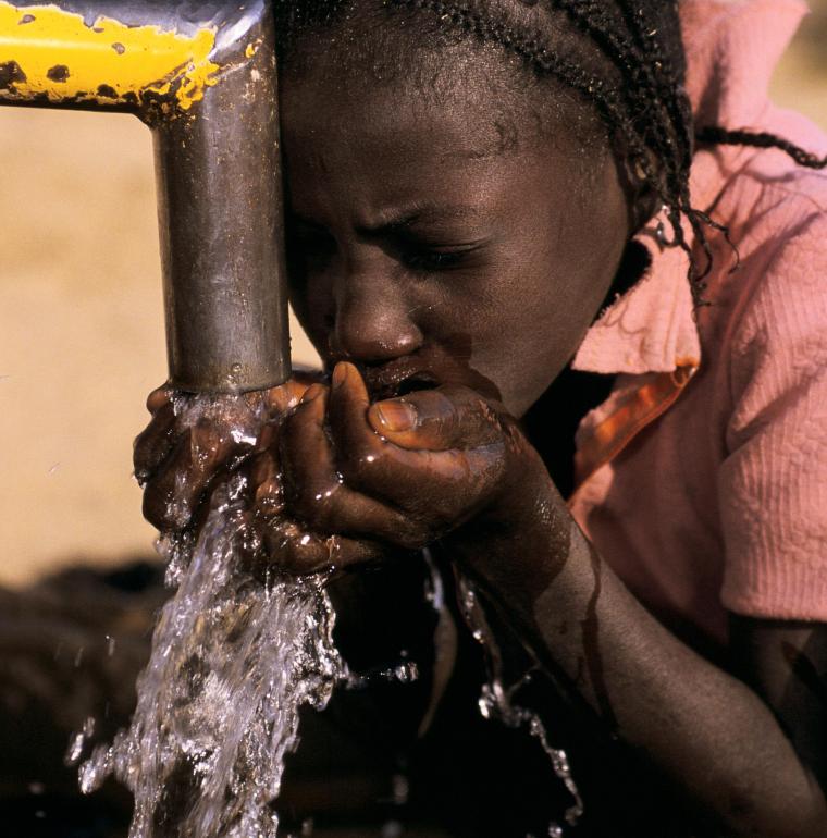 Mali, jeune fille buvant de l'eau fraîche à la pompe