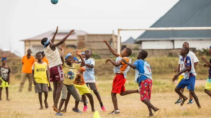 boys plaing football in a field